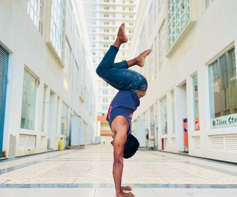 Scorpion handstand in a bright corridor